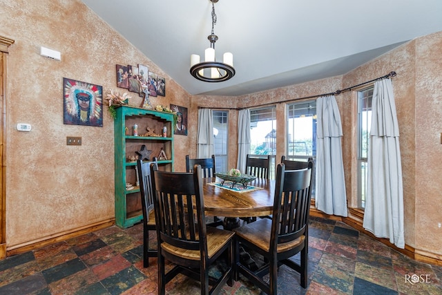 dining space with vaulted ceiling and a chandelier