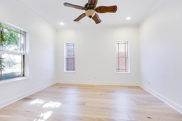 empty room featuring light wood-style floors, crown molding, baseboards, and a ceiling fan