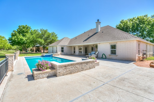 view of swimming pool with fence, a patio area, and a pool with connected hot tub
