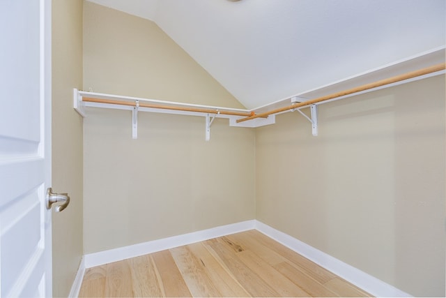 walk in closet featuring vaulted ceiling and light wood-style flooring