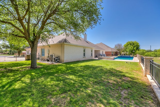 back of property with brick siding, a lawn, a patio, and a fenced backyard