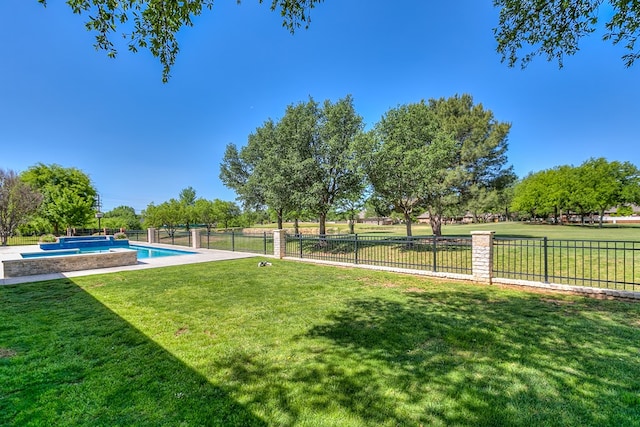 view of yard with a fenced in pool and fence