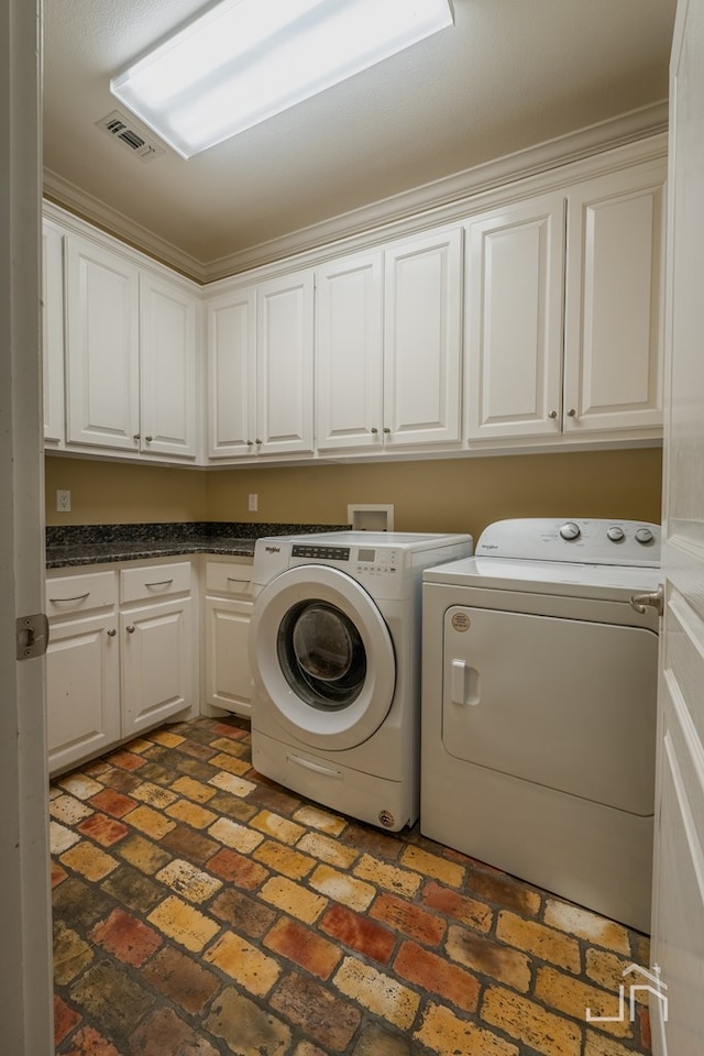 washroom featuring cabinets and independent washer and dryer