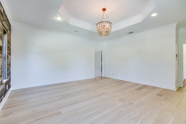 spare room with a chandelier, crown molding, and a tray ceiling
