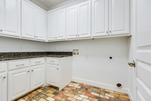 clothes washing area featuring brick floor, baseboards, electric dryer hookup, cabinet space, and washer hookup