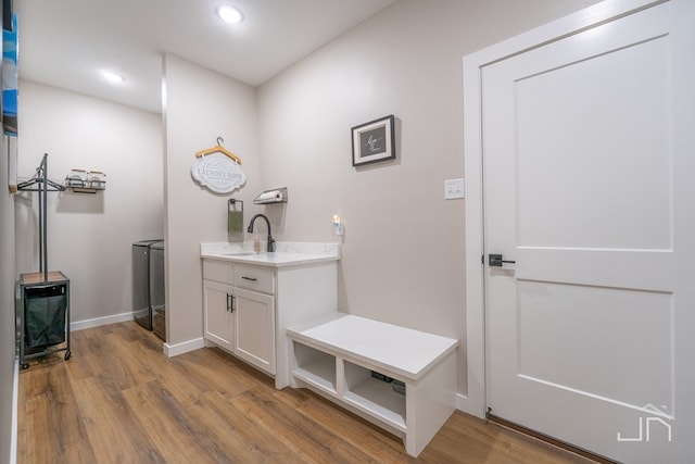 bathroom with recessed lighting, washer and clothes dryer, baseboards, and wood finished floors