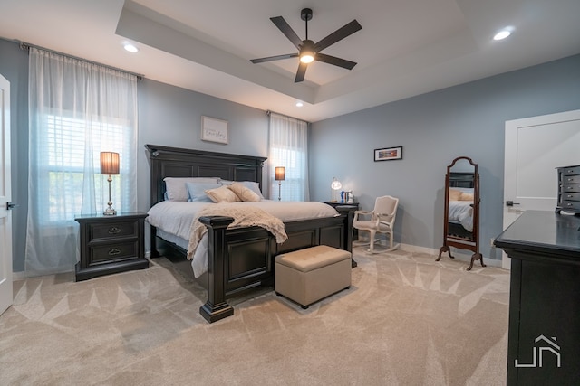 bedroom featuring baseboards, a raised ceiling, a ceiling fan, recessed lighting, and light carpet