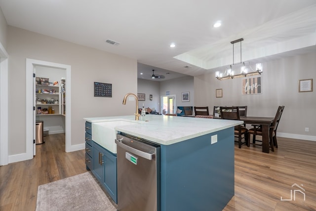kitchen featuring blue cabinetry, visible vents, wood finished floors, dishwasher, and a sink