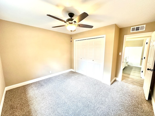 unfurnished bedroom with ceiling fan, carpet flooring, and a closet