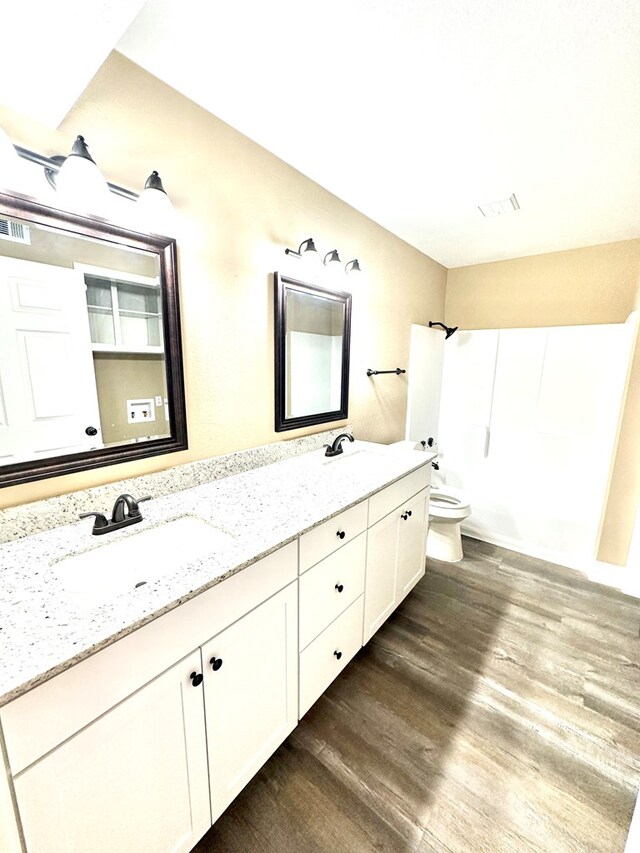 bathroom with hardwood / wood-style flooring, vanity, and toilet