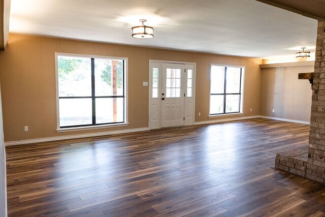 unfurnished living room with plenty of natural light and dark hardwood / wood-style floors