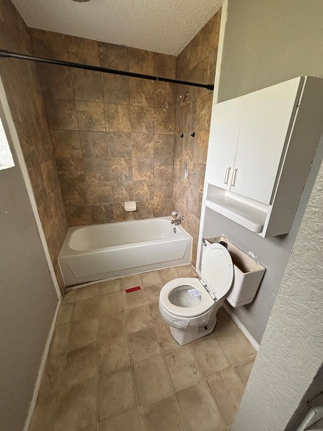 7646 Violet St, San Angelo, TX 76901 - full bathroom with toilet, bathtub / shower combination, a textured ceiling, tile patterned floors, and baseboards
