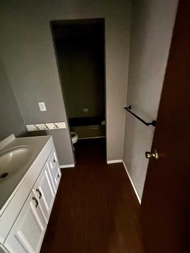 7646 Violet St, San Angelo, TX 76901 - bathroom with vanity, toilet, wood finished floors, and baseboards
