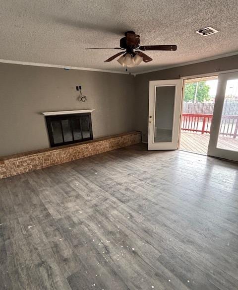 7646 Violet St, San Angelo, TX 76901 - unfurnished living room with ceiling fan, wood finished floors, a textured ceiling, and a glass covered fireplace