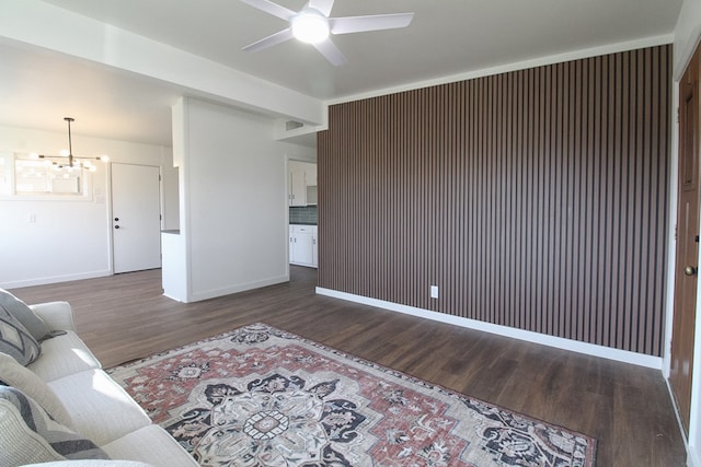 living room featuring dark hardwood / wood-style floors and ceiling fan with notable chandelier