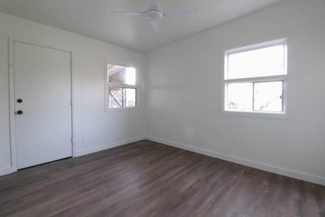 spare room featuring a healthy amount of sunlight, dark wood-type flooring, and ceiling fan