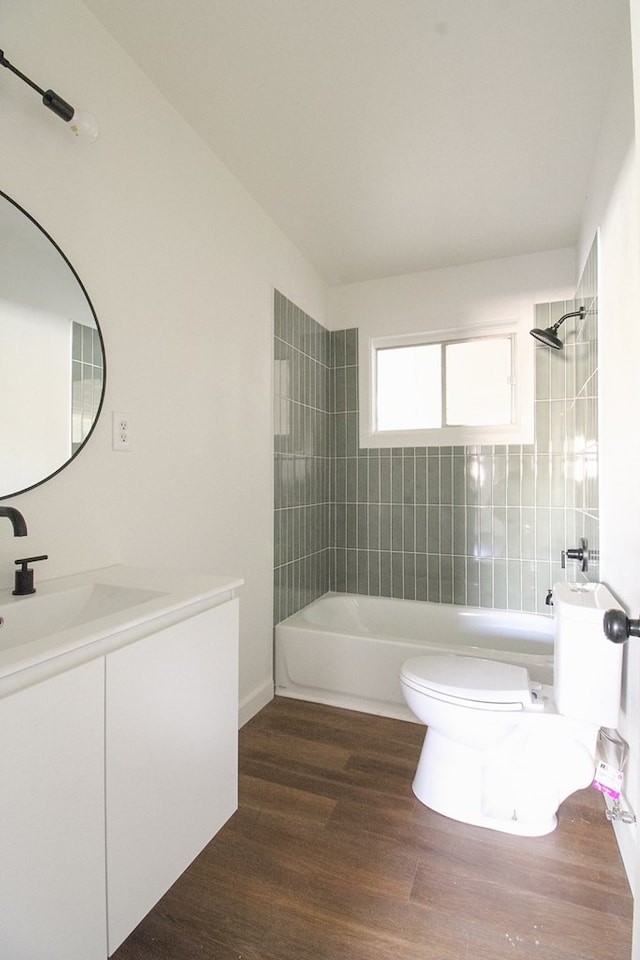 full bathroom featuring vanity, toilet, tiled shower / bath combo, and hardwood / wood-style floors