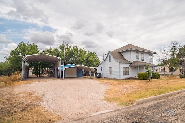 view of front of house with a carport and central AC unit