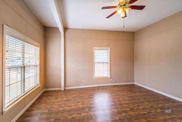 spare room with ceiling fan, dark hardwood / wood-style floors, and beam ceiling