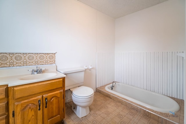 901 Koberlin St, San Angelo, TX 76903 - bathroom with toilet, a relaxing tiled tub, and vanity