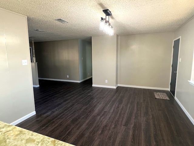unfurnished room with dark hardwood / wood-style flooring and a textured ceiling