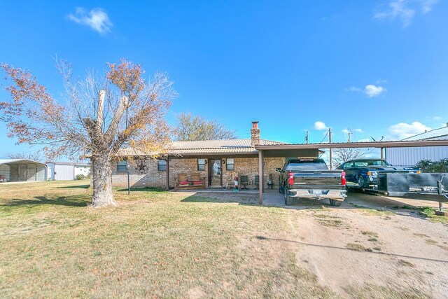 view of front of house featuring a carport and a front yard