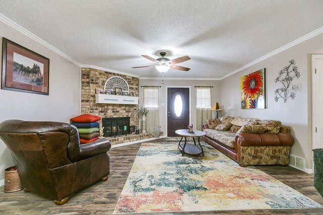 living room with ornamental molding, dark hardwood / wood-style flooring, and a textured ceiling