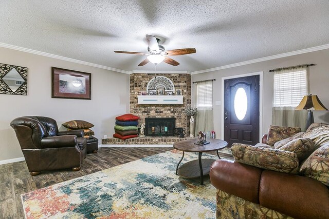 living room featuring ceiling fan, dark hardwood / wood-style floors, a fireplace, ornamental molding, and a textured ceiling