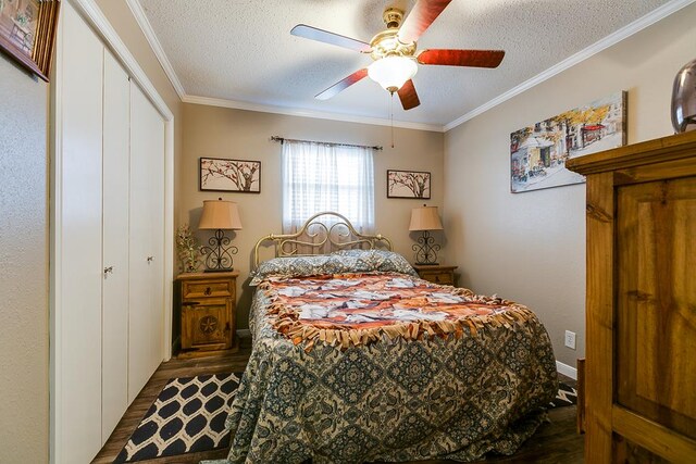 bedroom with ceiling fan, dark hardwood / wood-style flooring, a closet, and a textured ceiling