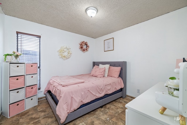 bedroom with stone finish flooring and a textured ceiling