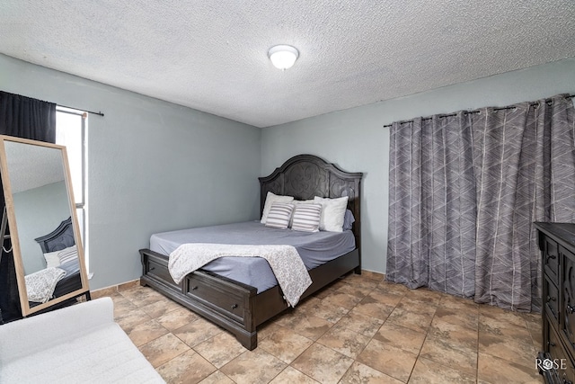 bedroom with a textured ceiling and baseboards