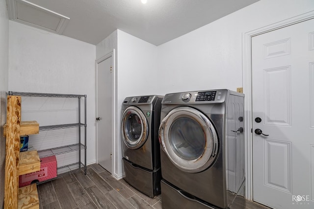 clothes washing area featuring a textured ceiling, laundry area, separate washer and dryer, wood finish floors, and attic access