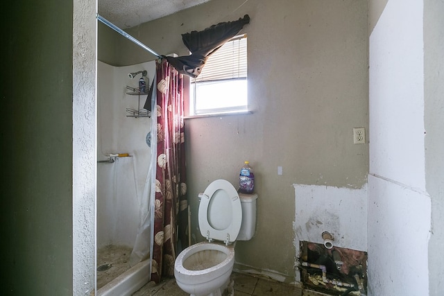 bathroom featuring toilet and curtained shower