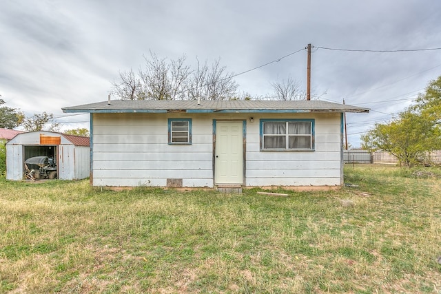 rear view of property featuring a lawn