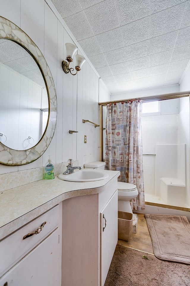 bathroom with vanity, ornamental molding, curtained shower, toilet, and wood walls