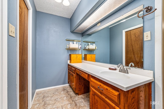1729 Parkview Dr, San Angelo, TX 76904 - bathroom featuring vanity, a textured ceiling, and stone finish flooring