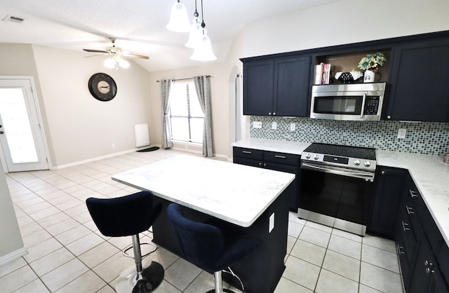 710 Penhurst Ct, San Angelo, TX 76901 - kitchen featuring stainless steel appliances, decorative backsplash, vaulted ceiling, light tile patterned floors, and a kitchen island