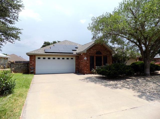 710 Penhurst Ct, San Angelo, TX 76901 - ranch-style house featuring solar panels, brick siding, driveway, and an attached garage