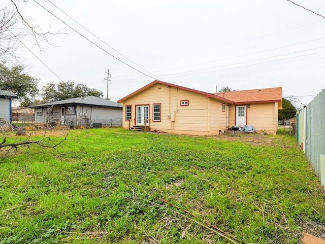 rear view of property featuring a yard