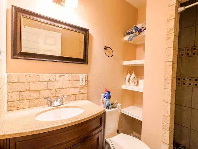 bathroom with vanity, built in shelves, a shower, and toilet