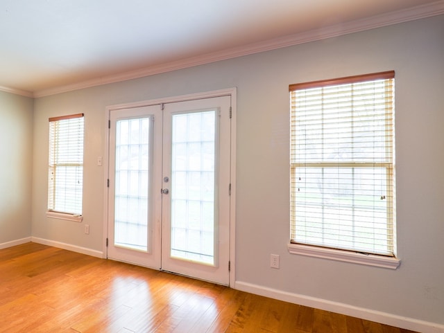 doorway featuring light hardwood / wood-style floors, ornamental molding, and french doors