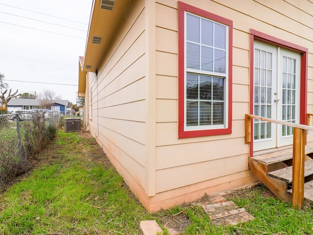 view of property exterior with french doors and central air condition unit