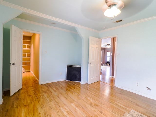 unfurnished room featuring ornamental molding, ceiling fan, and light hardwood / wood-style flooring