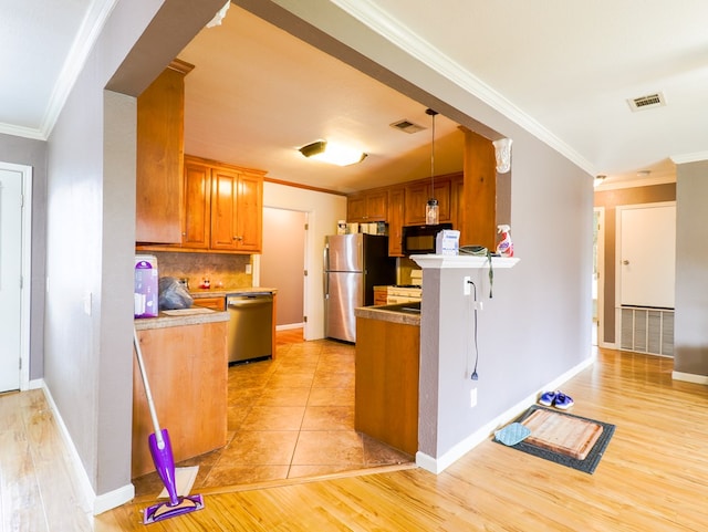 kitchen with tasteful backsplash, ornamental molding, stainless steel appliances, and decorative light fixtures