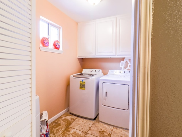 laundry room with separate washer and dryer and cabinets