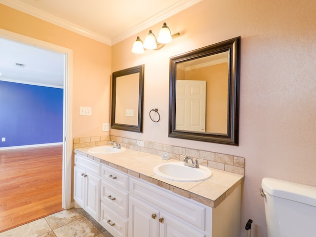 bathroom with tile patterned flooring, crown molding, vanity, and toilet