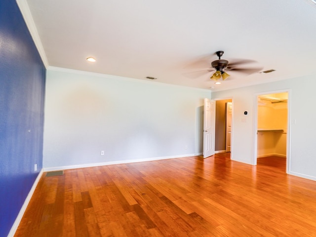 spare room featuring hardwood / wood-style floors, ornamental molding, and ceiling fan