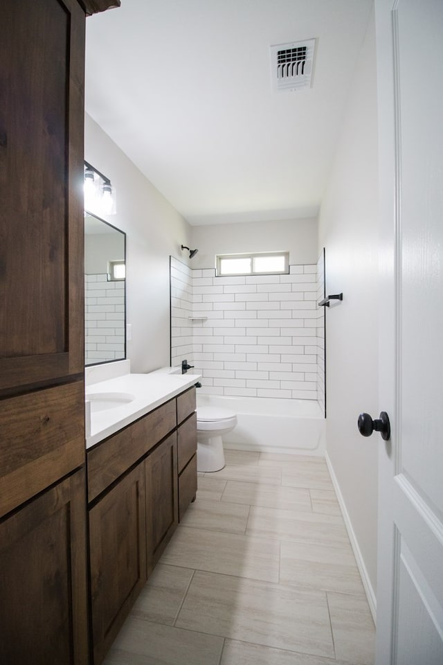 full bathroom with vanity, tiled shower / bath, tile patterned floors, and toilet