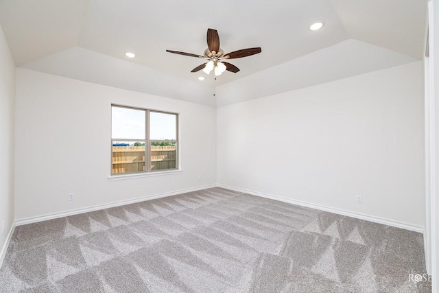 carpeted spare room featuring vaulted ceiling and ceiling fan