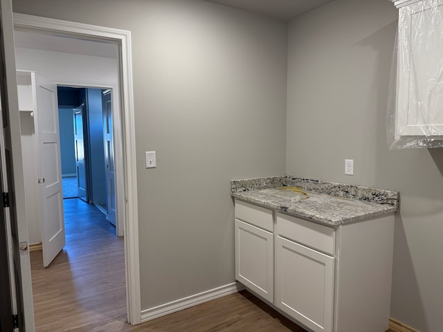 bathroom featuring baseboards, wood finished floors, and vanity